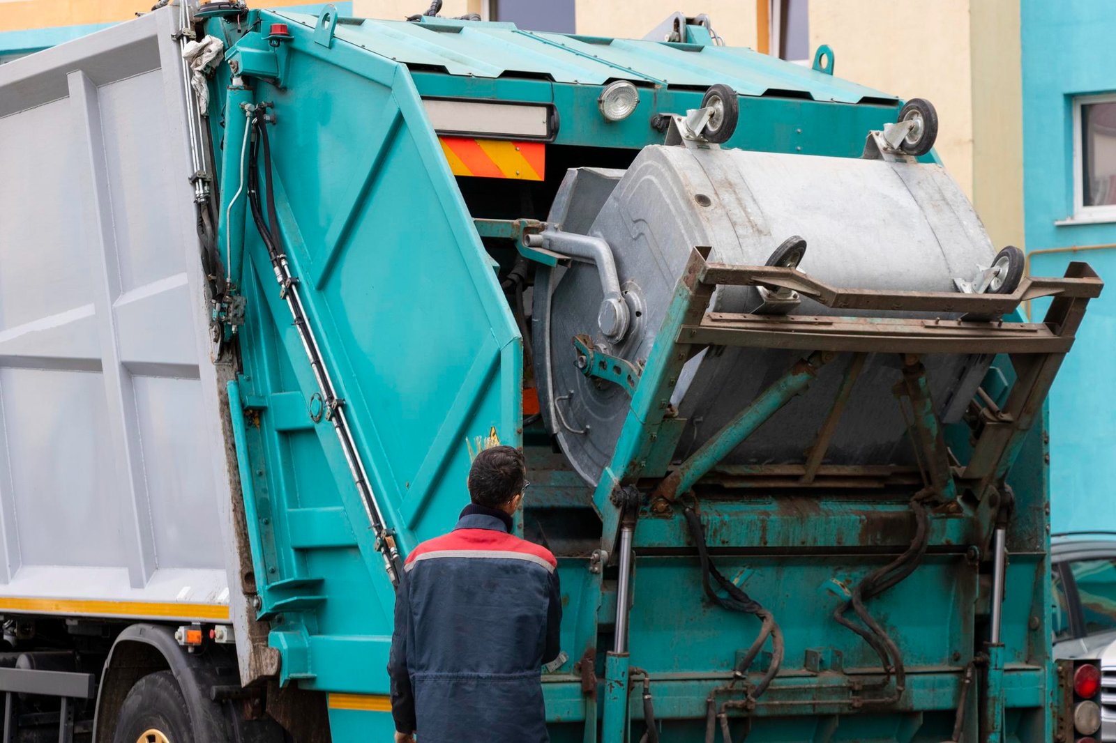 Garbage truck with worker loading waste