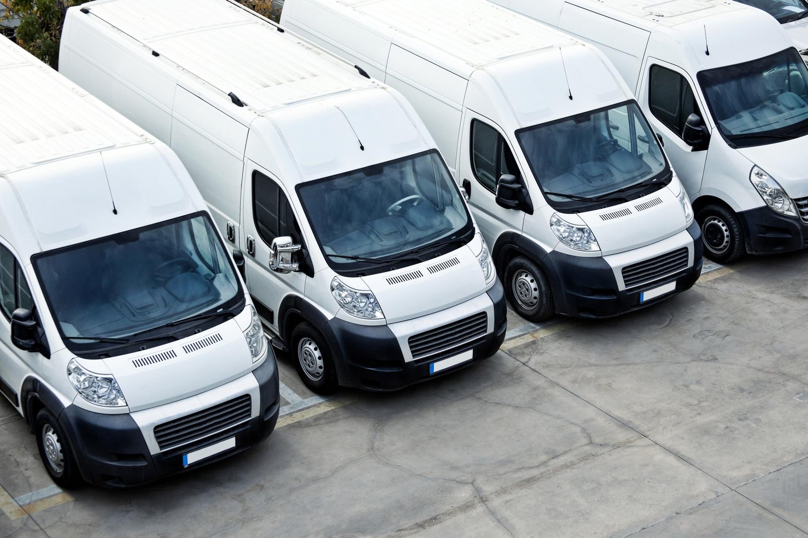 Fleet of white and black rental vans parked in a row